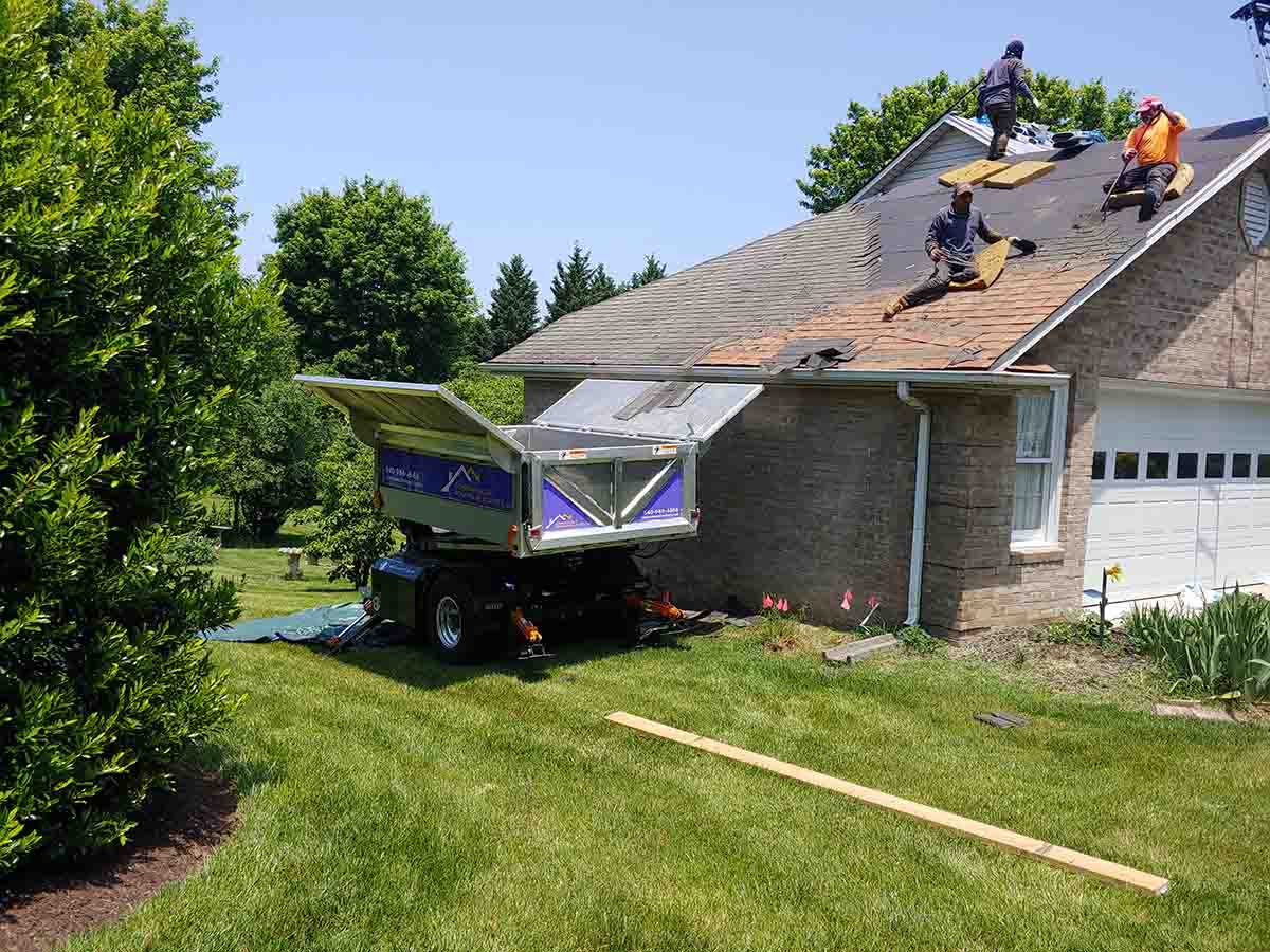 Commonwealth Roofing Specialists tearing up roofing shingles